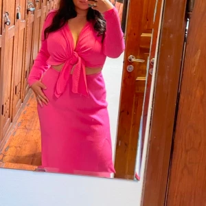 Adoore klänning - Trendig rosa ribbad klänning med knyt framtill från Adoore! Långärmad design och en smickrande v-ringning. Perfekt för en färgglad look🥰❤️ Använd vid ett tillfälle! 