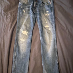 Replay anbass  - Snygga blå jeans från Replay, modell Anbass. De har en slim fit passform och är dekorerade med slitningar för en trendig look. Perfekta för en avslappnad stil. Dom här jeansen är i riktigt bra kvalité och är i ny skick./ny pris 1800/mitt pris 499