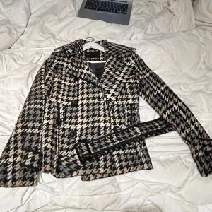 Mönstrad jacka  - Snygg rutig mönstrad kappa från Zara Basic i svart, beige och vit. Jackan har knappar och ett bälte för en stilren look. Super snygg men kommer tyvärr inte till användning. 