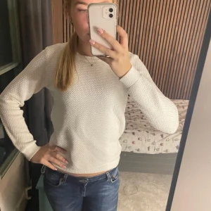 Vit stickad tröja - Säljer en vit stickad tröja med tröjan har en diskret textur som ger den en cool touch. 