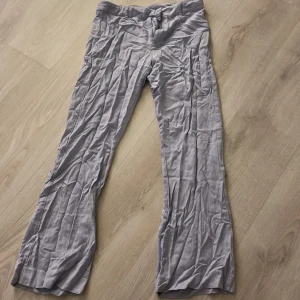 Ljusgrå linnebyxor från Gina Tricot - Snygga ljusgrå linnebyxor från Gina Tricot i storlek 34. Byxorna har en rak passform och är tillverkade i ett lätt och luftigt linne. Perfekta för en stilren look.