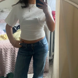 Vit tajt t-shirt - Snygg vit T-shirt från HM med sömmar i midjan så den sitter åt! Prislapp kvar!!!