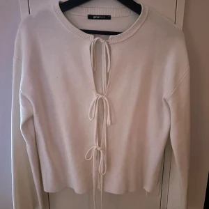 Vit kofta från Gina Tricot - Säljer vit kofta från Gina Tricot med knytning framtill, använd 1 gång.