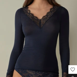 Mörkblå långärmad topp med spetsdetaljer - Elegant mörkblå topp med långa ärmar och v-ringad spetsdetalj vid halsen. Perfekt för en stilren look storlek s köpte för 549 säljer för 400 .