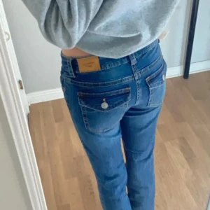 low waist jeans - blåa lågmidjade jeans med knappfickor från gina. köptes för 500kr. inga defekter! storlek: 32❤️