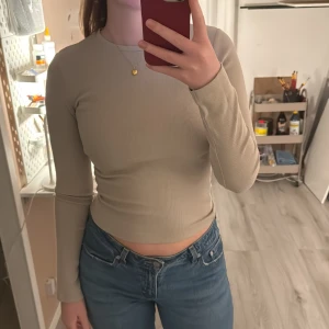 Beige ribbad topp - beige ribbad topp med långärmad design. Från bikbok i storlek xs. Använt fåtal gånger och har inga defekter eller liknanade