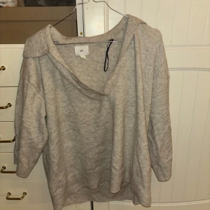 Beige tröja från H&M - Säljer en mysig beige tröja från H&M. Tröjan har en avslappnad passform med trekvartsärmar och en bred krage. Perfekt för en bekväm och stilren look.