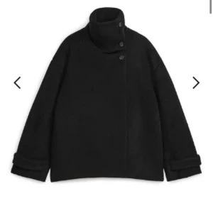 Svart kappa ARKET - Najs kappa från arket! Kan knäppas på lite olika sätt men väldigt snygg🥰 är 169cm lång som referens!