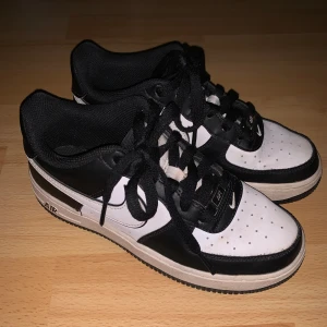 Nike Air Force 1s i svart och vitt - Snygga Nike Air Force sneakers i svart och vit färgkombo. Använts en del men har inga creases. Metallbrickan är i silver. Köptes för 1200kr. Kontakta mig för fler bilder eller frågor! Pris går att diskuteras!