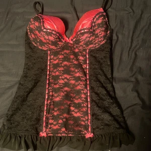 Rosa korsett liknande linne - Rosa och svart korsett liknande linne med söta detaljer. Skulle säga att den är xs-xxs då den är väldigt liten i storleken. Passar nog A-B kupa.
