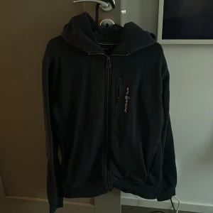 Mörkblå  hoodie från Sail Racing - Snygg svart hoodie från Sail Racing med dragkedja och huva. I princip ny skick, storlek Medium.. I princip nyskick använd fåtal gånger