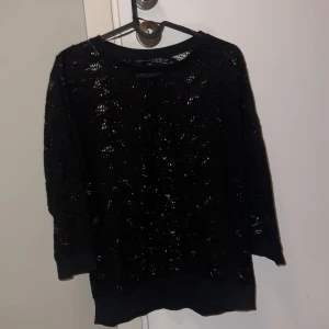 Svart spetsmönstrad tröja  - Snygg svart tröja från Atmosphere/Primark med ett  spetsmönster. Tröjan har trekvartsärmar och en bekväm passform. Perfekt för att ge en stilfull touch till din outfit.