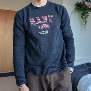 Mörkblå tröja från GANT storlek M - Snygg mörkblå tröja från GANT med tryck av amerikansk flagga och texten 'New Haven Conn. USA'. . 