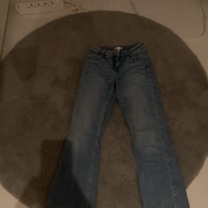 Blå jeansbyxor - Säljer ett par klassiska blå jeansbyxor med en snygg tvätt. De har en normal passform och är perfekta för vardagsbruk. Byxorna har en dragkedja och knappar framtill.