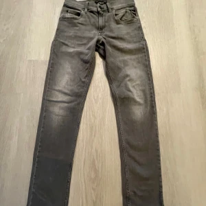 Grå replay jeans storlek 150 slim fit junior  - Snygga grå jeans från Replay med en klassisk femficksdesign. De har en slim passform och är perfekta för en stilren look. Tillverkade i ett slitstarkt material. Endast provade och tvättade en gång.