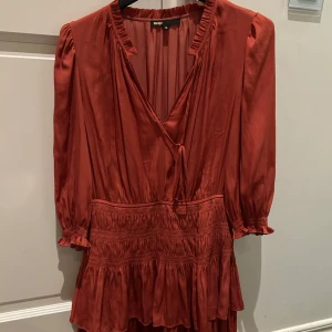 Maje klänning - Den klassiska omlottklänningen från maje fast i en unikare färg(lite ljusare i verkligheten) . Med v-ringad hals och trekvartsärmar. Klänningen har volangdetaljer och ett knytband i midjan för en smickrande passform.