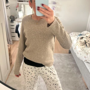 Beige stickad tröja - Mysig beige stickad tröja med rund hals och långa ärmar. Perfekt för kyligare dagar och enkel att matcha med olika outfits.