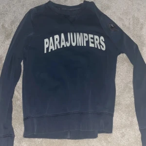 Mörkblå tröja från Parajumpers - Säljer en mörkblå tröja från Parajumpers med vit text på bröstet. Tröjan har långa ärmar och en rund halsringning. Perfekt för en avslappnad stil.