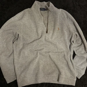 Ralph lauren quarter zip - Säljer en stilren grå tröja från Polo Ralph Lauren med halv dragkedja och broderad logga på bröstet. Perfekt för tex skolan eller tillfällen där du vill vara lite mer uppklädd. Tröjan är i nyskick och har endast blivit använd max 3 gånger, jag fick den i julklapp men tyvär är den lite för liten vilket är anledningen till varför jag säljer den. Kvitto finns och fler bilder kan jag självklart lösa. Tveka inte på att höra av er.