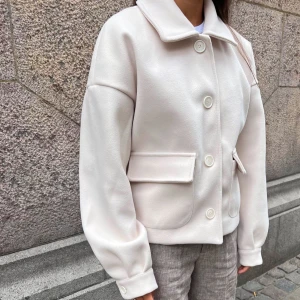 Vit kappa med knappar - Snygg vit kappa med stora knappar och bred krage. Jackan har en stilren design med två stora fickor framtill. Perfekt för en elegant look.För någon månad sen beställde jag hem denna super snygga kappa ifrån DesignBySi men jag har inte använt den mer än 2 gånger eftersom att jag fick i födelsedagspresent en liknande i en annan färg som jag tyckte om mer.  Därför har jag bestämt mig att sälja denna jackan nu (trotts att jag fortfarande överväger för att den är så otroligt fin:/)  Ord pris - 600 kr