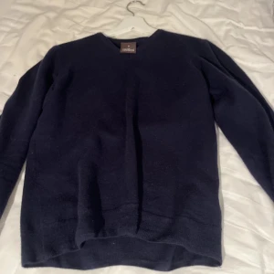 Oscar Jacobson  - Säljer en stilren mörkblå tröja från Gant. Tröjan har en klassisk design med U-ringning och långa ärmar. Perfekt för en avslappnad men ändå snygg look. Passar bra till både jeans och chinos.