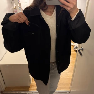 Svart jacka med bröstfickor - Säljer en stilren svart vårjacka med fickor framtill. Perfekt för lager-på-lager och har en klassisk krage. Passar bra till både jeans och chinos. Köpt secondhand.