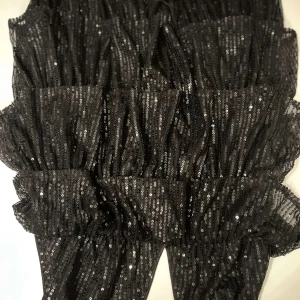 Svart glittrig klänning - Snygg svart klänning med glittriga paljetter och volangdetaljer. Perfekt för en festlig kväll. Klänningen har en åtsittande passform och är tillverkad i ett syntetmaterial som ger en elegant look. använd en gång