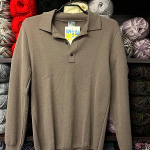 Brun pikétröja från RA-trikå - Säljer en stilren brun pikétröja från RA-trikå. Tröjan har en klassisk krage med knappar och långa ärmar. Perfekt för en avslappnad men ändå snygg look.