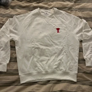 Vit sweatshirt från Ami Alexandre Mattiussi - Säljer en stilren vit sweatshirt från Ami Alexandre Mattiussi. Tröjan har endast använts ett fåtal gånger då den är för stor för mig. Perfekt för en avslappnad och trendig look.