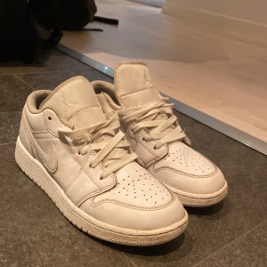  Nike Air Jordans - Säljer ett par vita Nike Air Jordans  i storlek 37,5 dom har en klassisk design och snörning. Skorna har perforerade detaljer för ventilation och en ikonisk logga på hälen. Perfekta för en stilren look. Hör av dig vi frågor!