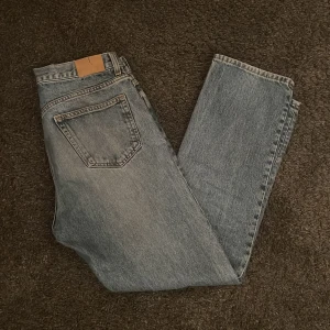 Blå jeans från Weekday - Säljer ett par klassiska blå jeans från Weekday i modellen Space Released Straight. De har en rak passform.