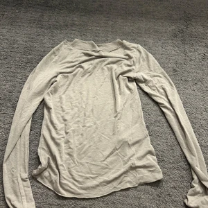 Beige långärmad topp från Vero Moda - Säljer en stilren beige långärmad topp från Vero Moda. Perfekt för lager-på-lager eller att bära som den är. Toppen är tillverkad i ett mjukt material som känns skönt mot huden. Den är lite genomskinlig (intimissme vibe)