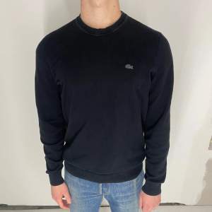 Säljer en stilren svart tröja från Lacoste med rund halsringning och det svarta krokodilmärket på bröstet. Fint skick, inga fel. Det står storlek M men passar som S. Modellen är 173cm och väger 65kg. 