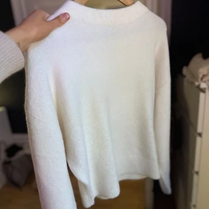 Vit stickad  tröja från Zara - Säljer en stilren vit tröja från Zara. Tröjan har en enkel design med långa ärmar och ett super mjukt material, använts vid något tillfälle ny pris 499kr