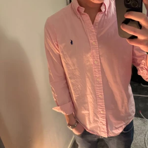 Rosa skjorta från Ralph Lauren - Snygg rosa skjorta från Ralph Lauren som passar perfekt till soliga dagar eller festtillfällen!🍾 Skjortan är i Storlek S! Byten kan även vara intressant så tveka inte på att höra av dig!✌🏻