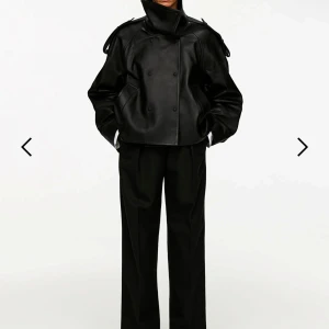 ARKET Svart skinnjacka med hög krage - Snygg svart skinnjacka med hög krage och dubbelknäppning. Jackan har en cool oversized passform och långa ärmar. Perfekt för att ge din outfit en edgy touch. Ordinarie pris 7990:-                 Alla lappar sitter kvar och kvitto finns. 