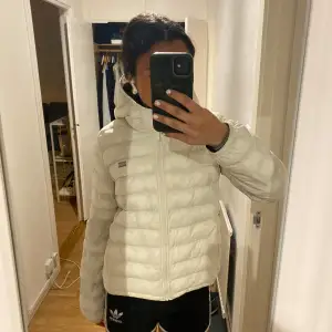 Säljer en snygg vit dunjacka från Levi's med huva och dragkedja. Jackan har en quiltad design och är perfekt för kyligare dagar. Den är lätt och bekväm att bära, vilket gör den till ett utmärkt val för både stad och natur. Nypris 2000kr 💕 skriv om frågor och funderingar 