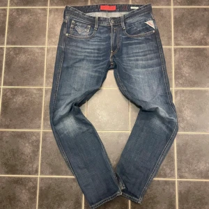 Blå jeans från Replay - Snygga blå jeans från Replay, modell Anbass. De har en klassisk femficksdesign med Replay-logga på myntfickan. Jeansen har en slim passform och är tillverkade i slitstarkt denim.