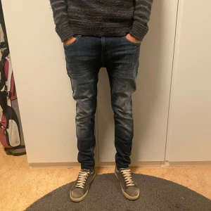 Mörkblå jeans - Snygga mörkblå jeans med en slimfit passform. De har lätt slitna detaljer för en trendig look. Modellen är 185cm. Storleken är 29/32 men passar större. PRUTBART VID SNABB AFFÄR, DM vid frågor!
