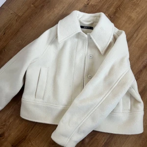 Vit höstjacka  - En vit jacka från Gina Tricot som är perfekt till hösten. Inköpt förra året men använd 1 gång. Har två mindre fläckar på kragen som man kan se på de två sista bilderna. Storlek XS, inköps pris 600kr. Säljes då jag inte får användning för den. 