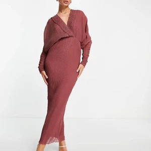 Röd långklänning med omlott - Säljer en elegant röd långklänning med omlott-design. Klänningen har långa ärmar och en v-ringad hals. Perfekt för festliga tillfällen!