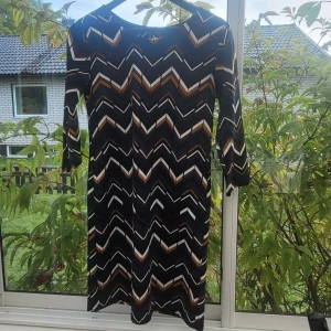 Klänning - Klänning i väldigt bra skick! Oklart storlek/material. Uppskattar M. Sitter figurnära , lite tjockare tyg. Känns kvalitet. Inhandlad på second hand. Väldigt snygg i mitt tycke med coolt mönster. 