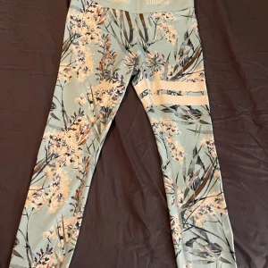 Stronger träningsbyxor - Ljusblåa strongerbyxor med blommönster. Aldrig använda. 