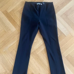 Other stories svart kostymbyxa stl 44 - Snygg svart kostymbyxa dam. Other stories. Slits nedtill i benen. Blixtlås i sidan. Bra kvalitet, nästan oanvänd. Stl 44