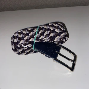 Flätat bälte - Bältet är elastiskt och man kan sätta hål överallt eftersom att den är flätad. Detta gör det till en jätte skön produkt och jätte enkelt bälte. Bältet har flera olika mest mörka färger som gör det till ett perfekt bälte till Dom som gillar atkläupsig