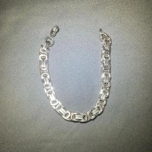 Silverfärgat armband med kedjedesign - Snyggt och stilrent armband i silverfärg med en cool kedjedesign. Perfekt för att ge en extra touch till din outfit, oavsett om det är till vardags eller fest. Armbandet har en robust känsla och är lätt att matcha med andra smycken.