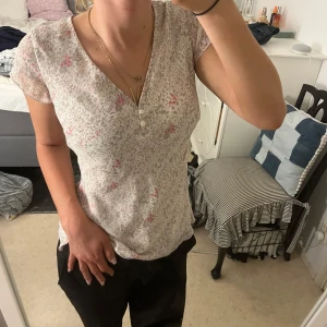 Blommig topp från Kappahl - Säljer en söt blommig topp från Kappahl i storlek 38 massar även 34,36. Den är vit med små rosa och grå blommor, har en v-ringad hals. ❤️