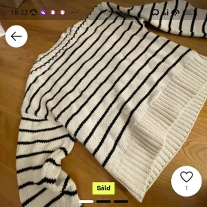 Vit och svart randig stickad tröja - Säljer en supermysig vit stickad tröja med svarta ränder. Den har långa ärmar och en ribbad kant vid ärmslut och nederkant. Perfekt för kyliga dagar och passar till allt! 🖤🤍 (Köpt på plick men var för liten) 