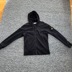 Stone Island Zip Hoodie - Tja, Säljer en Stone Island Zip Hoodie då den är för stor för mig. Passar dig bäst som är mellan 180-190. Självklart äkta. Alla taggs finns kvar samt är badgen i toppskick. Inga skador. Skick 9,5/10. Använd typ 3 gånger. Pris kan diskuteras.