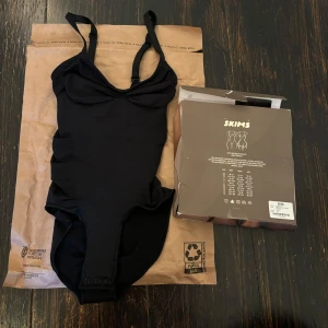 Skims body i totalt nyskick  - Helt oanvänd. Fick den för 2 dagar sen men var för liten så fick inte på mig den. Är i xxs och heter SEAMLESS SCULPT BRIEF BODYSUIT | ONYX på hemsidan. Har kvar förpackningen.